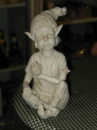 Elf mit Blumenstrauss im Schneidersitz